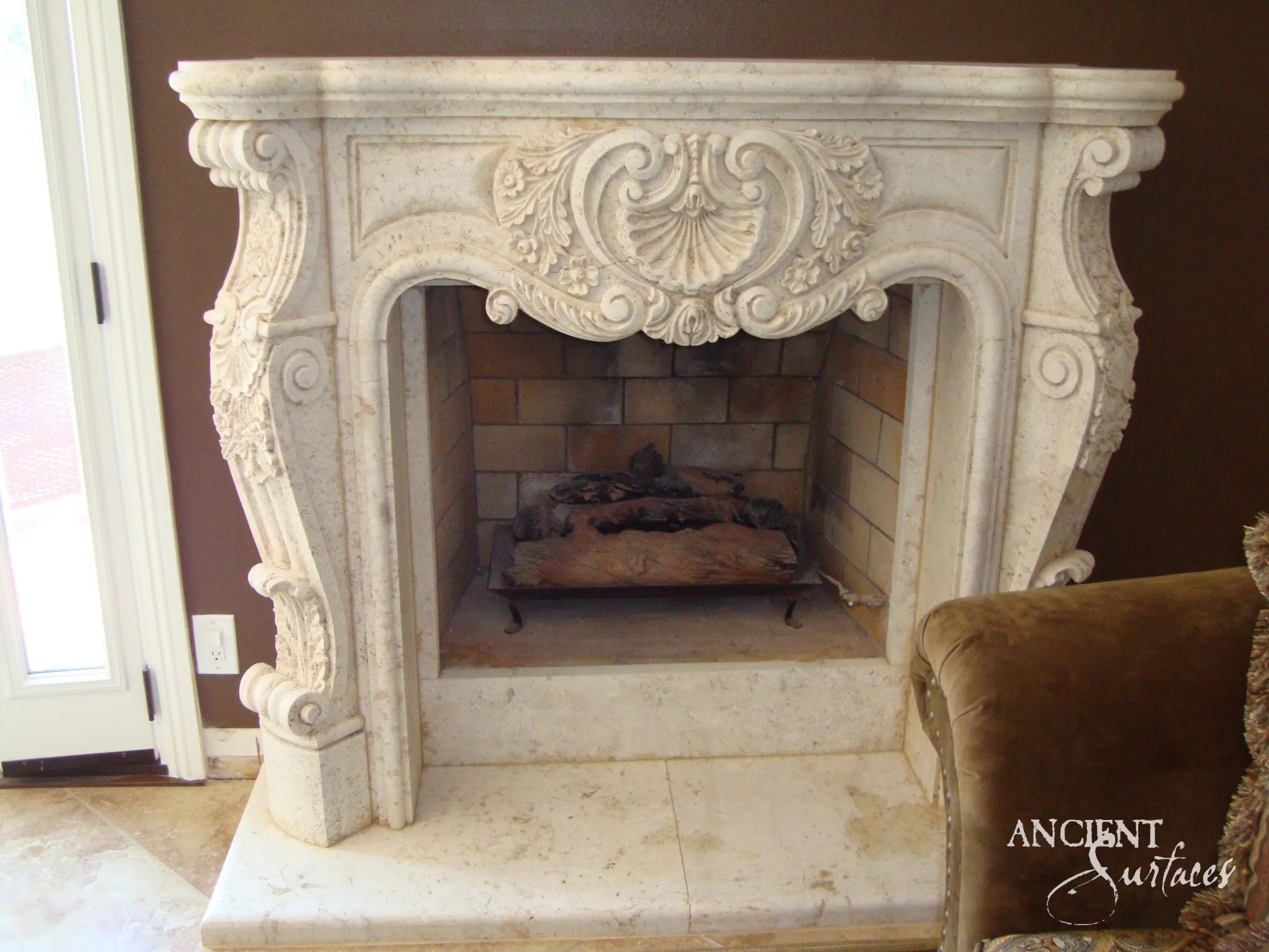 Rococo reclaimed limestone fireplace mantel with a carved shell cartouche and cabriole scroll legs