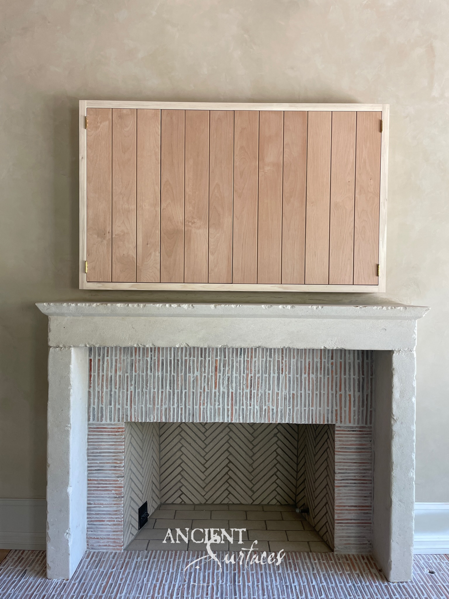 Reclaimed antique limestone fireplace mantel with a carved rosette frieze over a Tudor-arch opening